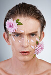 Self love, skincare and flowers with portrait of man in studio for beauty, natural and creative. Glow, cosmetics and spring with face of model on white background for makeup, spa and floral wellness