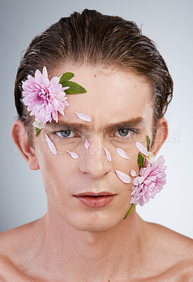 Buy stock photo Serious, skincare and flowers with portrait of man in studio for beauty, natural and creative. Glow, cosmetics and aesthetic with face of model on white background for makeup, spa and floral