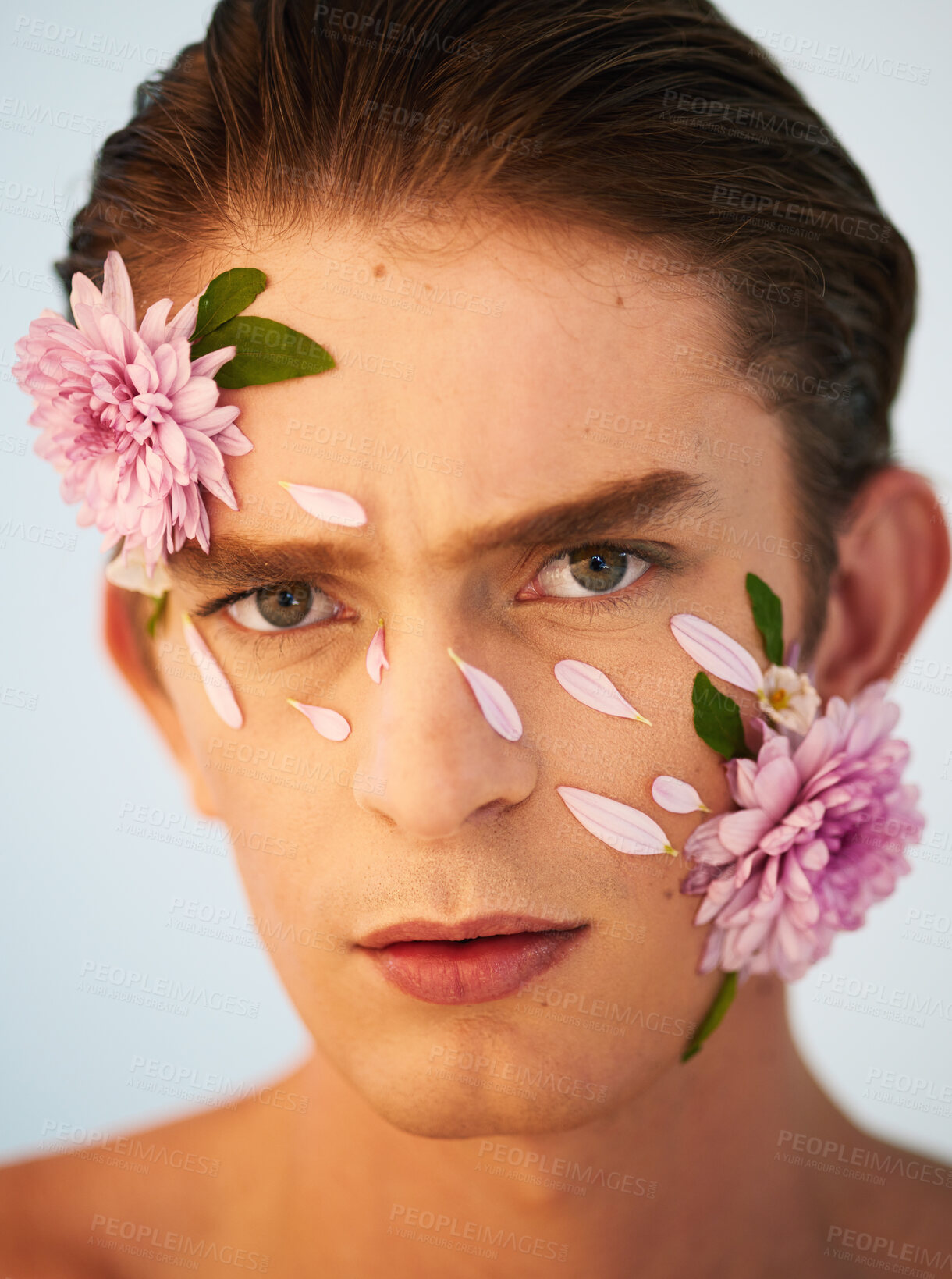 Buy stock photo Beauty, aesthetic and flowers with portrait of man in studio for petals, natural and creative. Glow, cosmetics and spring with face of model on white background for makeup, spa and floral wellness