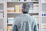 Patient, pharmacy and checking pharmaceutical shelf for medication, healthcare or boxes at the drugstore. Rear view of customer in search for medical product, supplements or antibiotics at the clinic