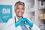 Senior, happy woman and portrait of doctor with heart sign for healthcare, service or love at hospital. Mature female person or medical professional smile in happiness, like emoji or hands at clinic