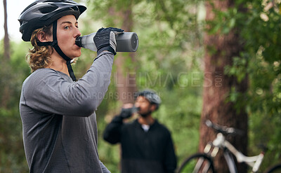 Buy stock photo Forest, cyclist and men drinking water, exercise and tired with workout, refreshing and fitness. Healthy people, athlete and bikers in the woods, hydration and outdoor with liquid, bottles and helmet
