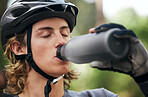 Forest, cyclist and man drinking water, fitness and wellness with hydration, exercise and workout. Healthy person, athlete or biker in the woods, refreshing or outdoor with liquid, training or helmet