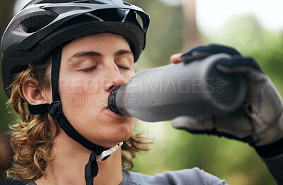 Buy stock photo Forest, cyclist and man drinking water, fitness and wellness with hydration, exercise and workout. Healthy person, athlete or biker in the woods, refreshing or outdoor with liquid, training or helmet