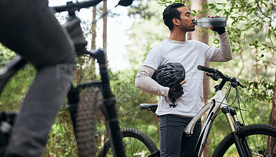 Buy stock photo Forest, bike and man drinking water, exercise and fitness with workout, refreshing and wellness. Healthy person, athlete or cyclists in the woods, hydration and outdoor with liquid, nature and helmet