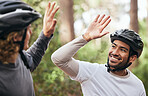 Forest, cyclist and friends with high five, support and exercise with fitness, smile and motivation. People, men and bikers with gesture, woods and challenge with progress, workout and achievement