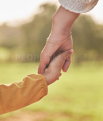 Buy stock photo Mother, child and holding hands for walking in park for support, trust and care together or bonding in nature. Love, comfort and parent help kid in the morning sunshine with kindness on weekend