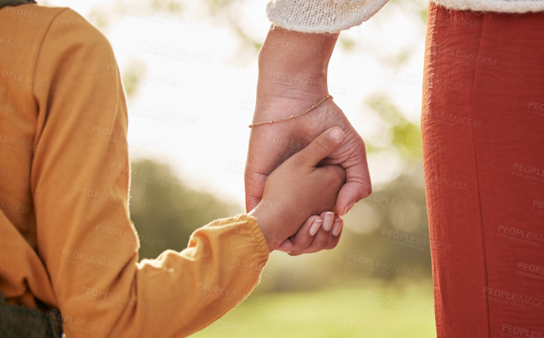 Buy stock photo Mother, kid and holding hands for walking in park for support, trust and care together or bonding in nature. Love, comfort and parent help child in the morning sunshine with kindness on weekend
