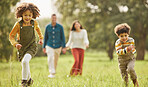 Running, park and parents with children in nature for playing, bonding and fun together in field. Happy family, mother and father with kids outdoors for freedom on holiday, adventure and vacation