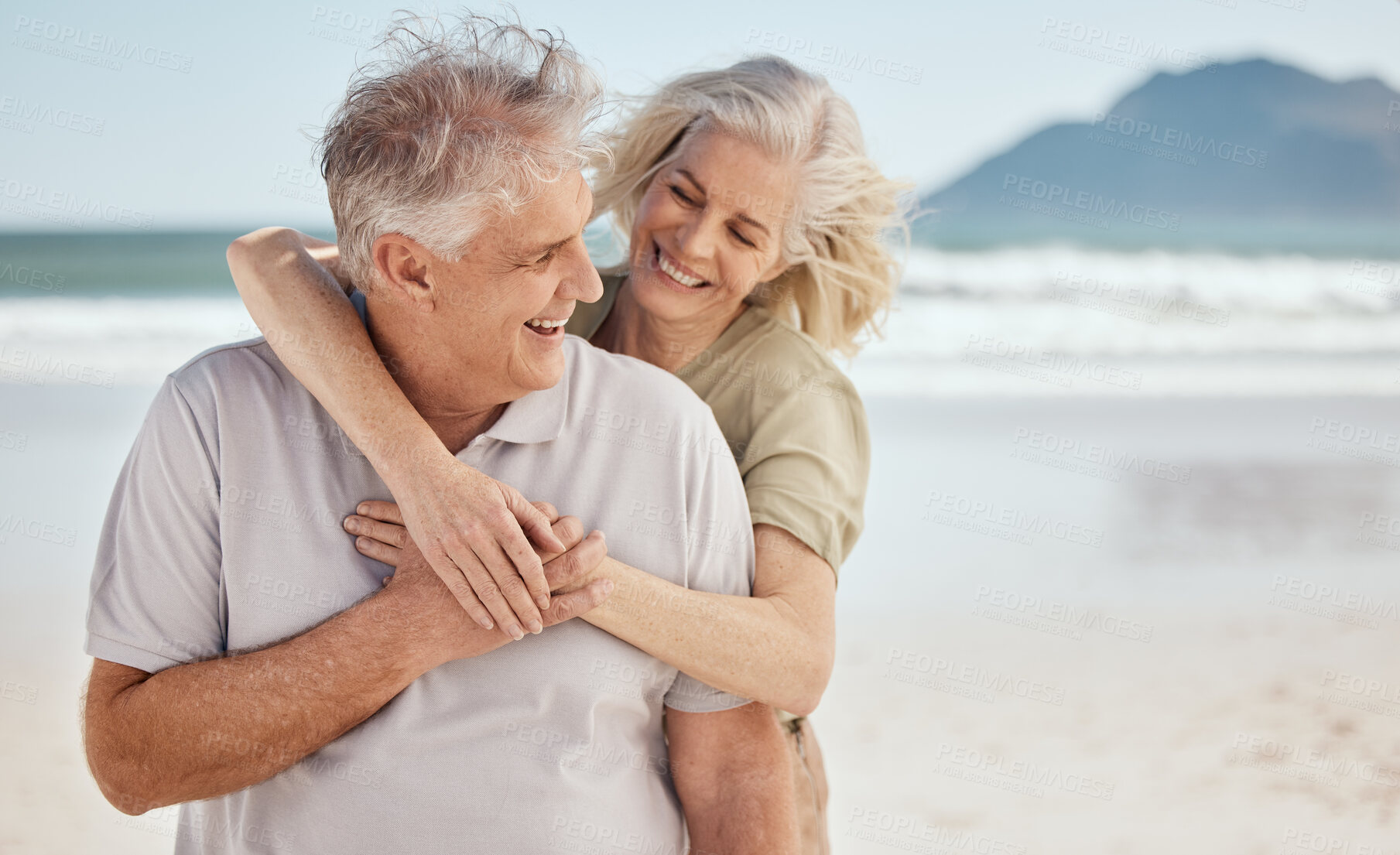 Buy stock photo Hug, senior couple and outdoor at the beach with happiness, love and care on vacation. Man and woman on retirement holiday, adventure and romantic trip in nature to relax and travel with mockup
