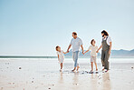Travel, walking and family holding hands at the beach on vacation, holiday or adventure together. Bonding, fun and children with their mother and father by the ocean for fresh air on a weekend trip.