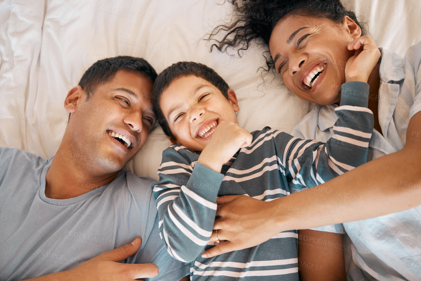 Buy stock photo Funny, tickle and relax with family in bedroom for playful, morning and love from above. Care, support and wake up with parents and child in bed at home for weekend, positive and happiness together