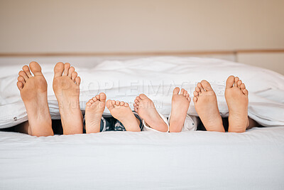 Buy stock photo Sleeping, relax and feet with family in bedroom for calm, morning and love. Care, support and wake up with closeup of parents and children in bed at home for weekend, peace and resting together