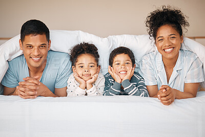 Buy stock photo Morning, portrait and relax with family in bedroom for playful, happy and love. Care, support and wake up with parents and children laughing in bed at home for weekend, positive and smile together