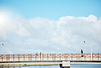 Fitness, sky and a man running on a bridge for a cardio or endurance workout with cloudy mockup. Exercise, sports and training for a marathon with a male runner or athlete outdoor for a challenge