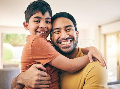 Buy stock photo Happy, portrait and father hugging his child in the living room of a modern house for bonding. Smile, love and excited young dad embracing his boy kid from Colombia in the lounge of a family home.