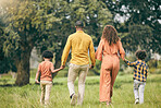 Parents, holding hands or kids walking in nature, park or field on holiday vacation together as a family. Back of mother, father or children siblings bonding to relax in countryside for love or trust