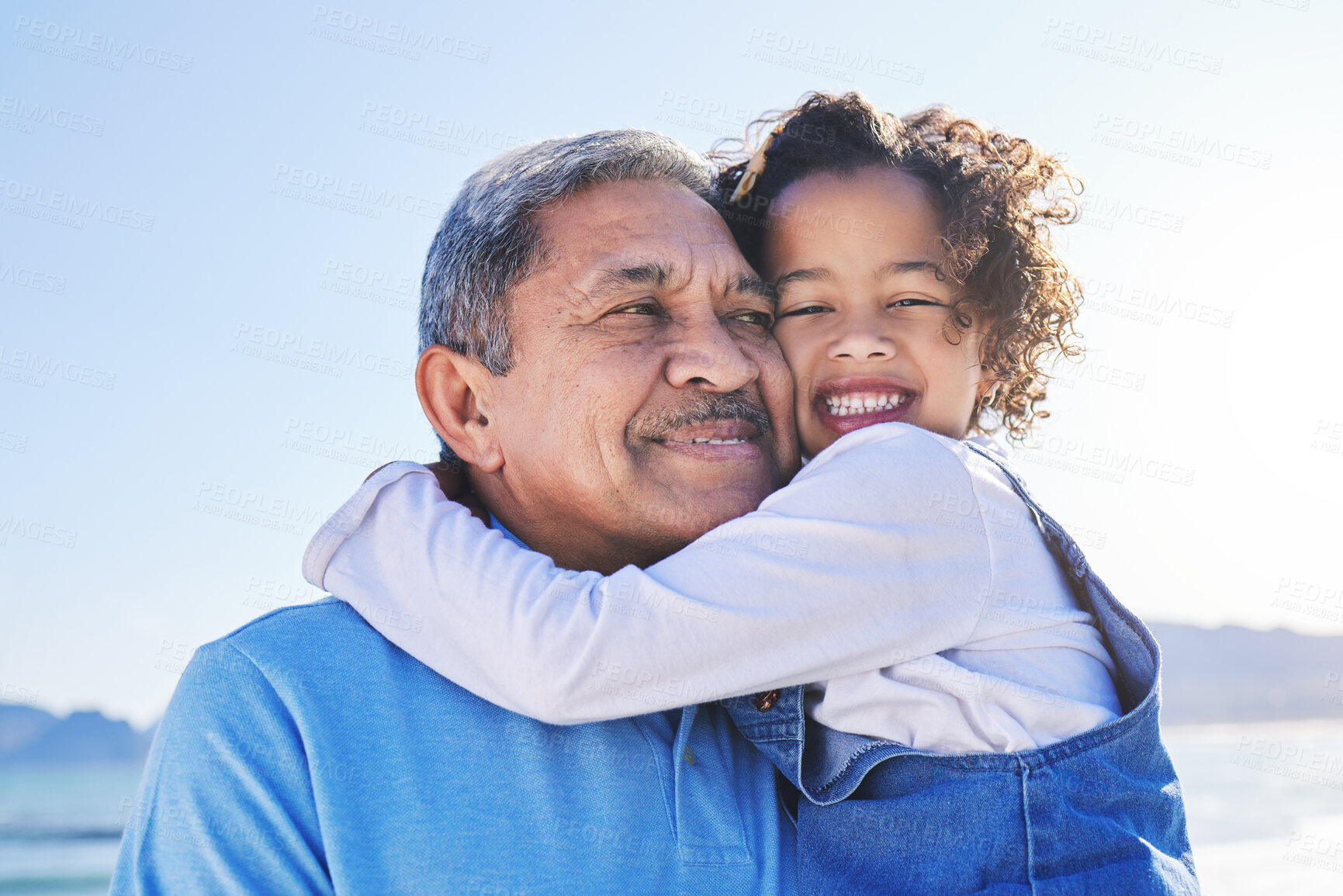 Buy stock photo Grandfather, child and happy at the beach for vacation and travel together on outdoor holiday for happiness. Hug, smile and grandparent with kid or young grandchild by the ocean or sea for adventure