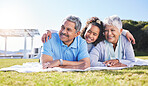 Grandparents, girl and blanket on grass, relax and smile with hug, love and picnic on family vacation in summer. Senior man, woman and grandchild with embrace, thinking and happy in sunshine on lawn