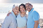 Beach, portrait and woman with her senior parents hugging and bonding on vacation together. Happy, smile and female person embracing her elderly mother and father by ocean on holiday or weekend trip.