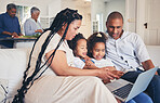 Laptop, social media or gaming with parents and children on a sofa together in the living room of their home. Computer, website and a family on the internet for browsing while in a house to relax