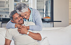 Senior couple, hug and love in care, support or embrace and bonding on living room sofa together at home. Happy mature man and woman smile in happiness for romance, weekend break or relax in house