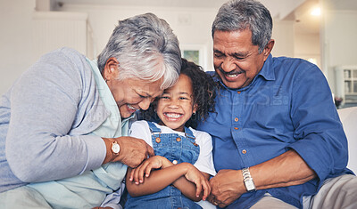 Buy stock photo Grandparents tickling child, happiness and funny, relax at home at the weekend with retirement and love. Fun, playful and old people with young kid on sofa in living room, laughter and bonding