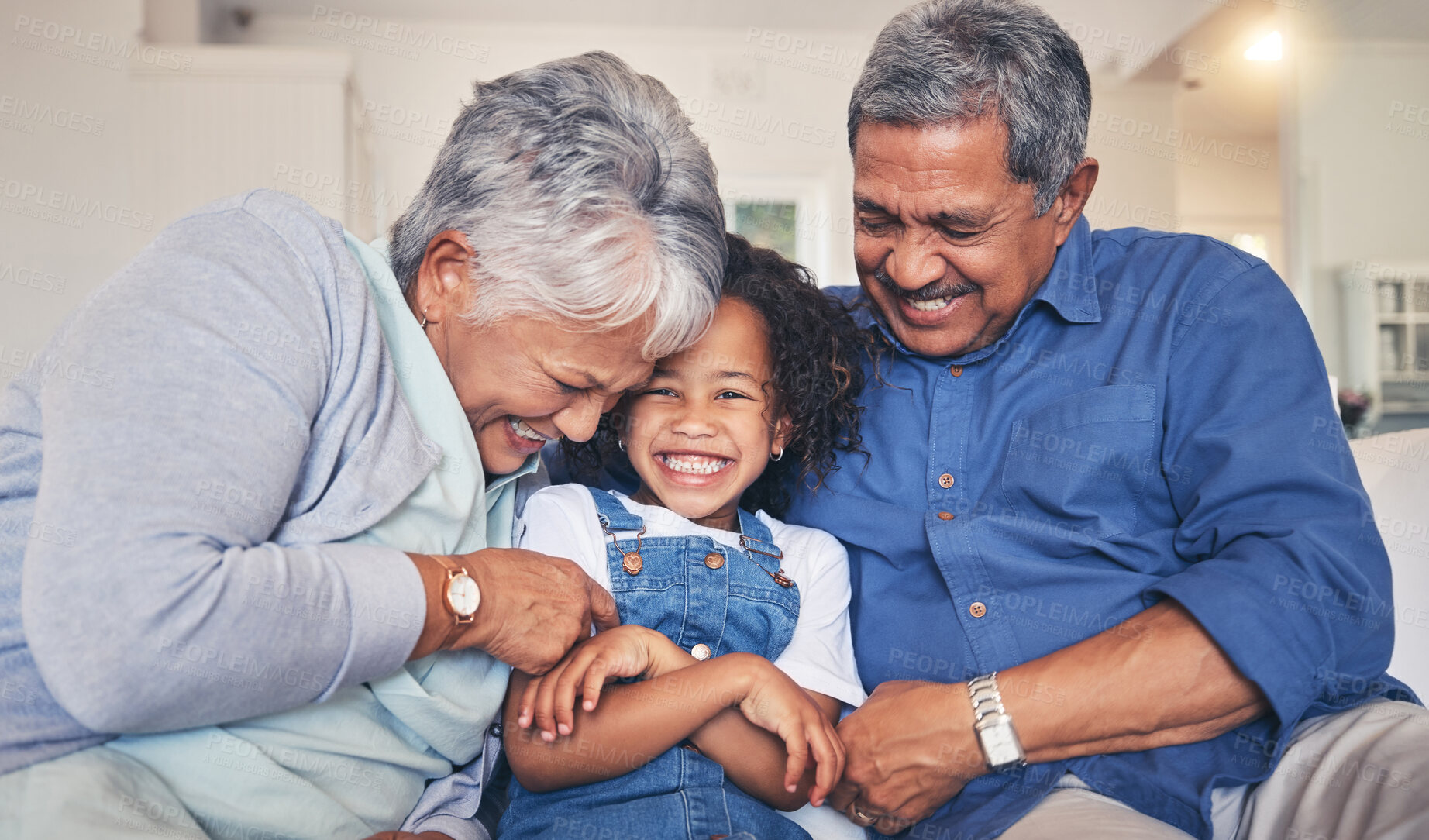 Buy stock photo Grandparents tickling child, happiness and funny, relax at home at the weekend with retirement and love. Fun, playful and old people with young kid on sofa in living room, laughter and bonding