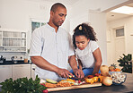 Father, teaching or child cooking healthy food in kitchen in preparation for a vegan diet for dinner together. Education, dad or kid learning vegetable salad recipe at home for lunch or development