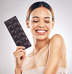 Woman, chocolate and thinking of diet for skincare, beauty and health or wellness on a white background. Young person or model with cocao product, food or candy for skin care or dermatology in studio