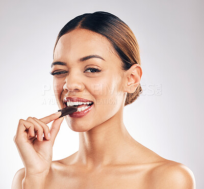 Buy stock photo Chocolate, wink and portrait of woman in studio with diet, detox or sweet, unhealthy and snack on white background. Face, emoji and female model with sugar, candy bar or eating isolated cocoa treats