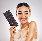 Skincare, portrait and happy woman in studio with dark chocolate for anti aging benefits on white background. Sugar, beauty and lady model face smile with candy bar for collagen, diet or circulation