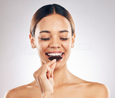 Buy stock photo Woman, eating chocolate and thinking of diet for skincare, beauty and inner health on white background. Young person or model with cacao product, food or candy for skin care or dermatology in studio