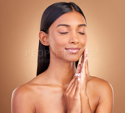 Buy stock photo Woman, eyes closed and face for natural skincare, aesthetic glow or smile for clean dermatology on brown background. Happy indian model, beauty or shine in studio for self care of soft facial results