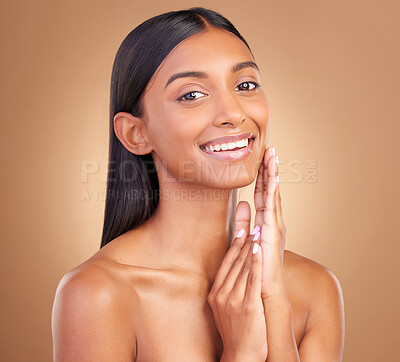 Buy stock photo Portrait, woman and touch face for skincare, aesthetic glow and smile for clean dermatology on brown background. Happy indian model, natural beauty and shine in studio for self care of facial results