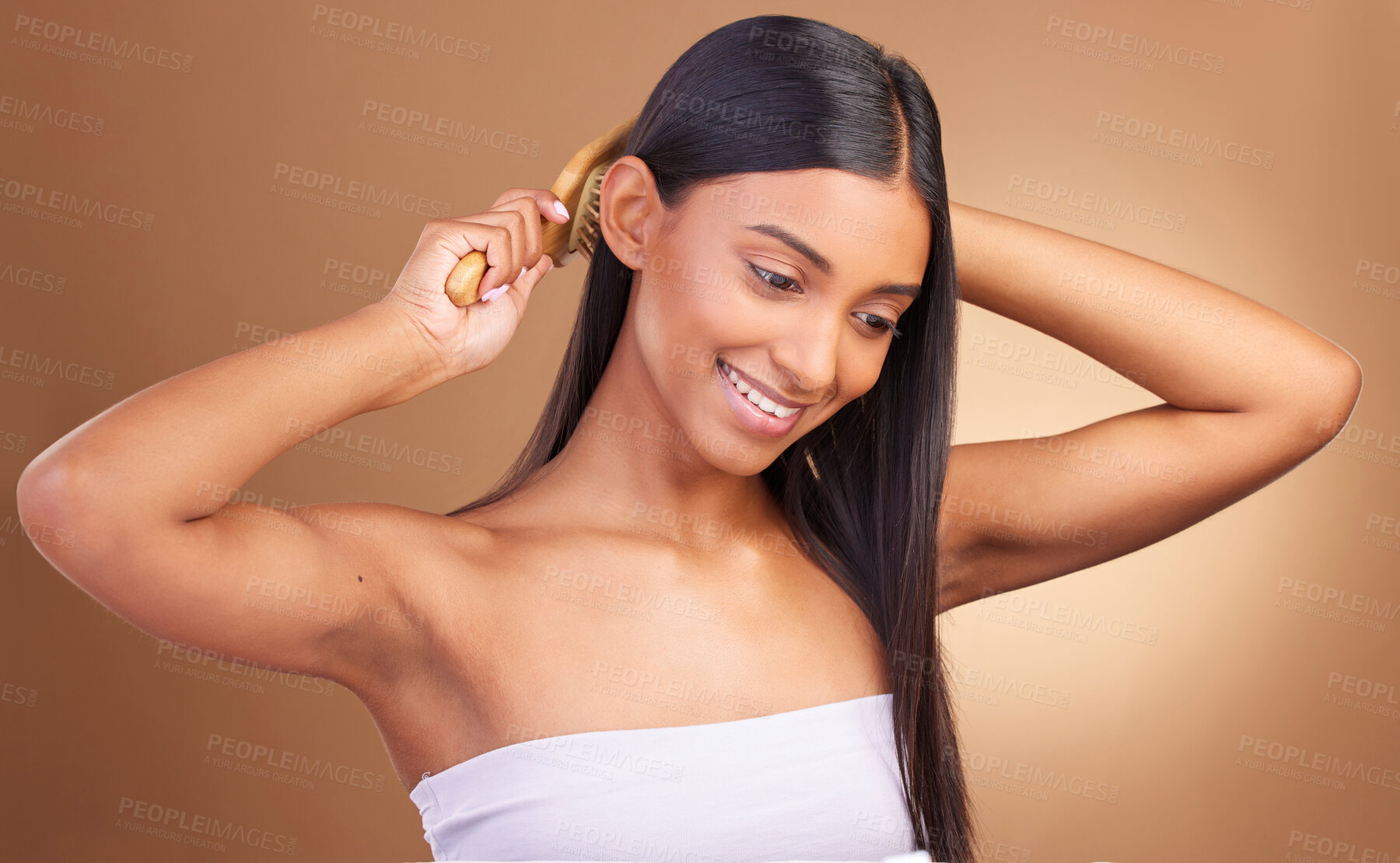 Buy stock photo Beauty, smile and woman brushing hair in studio for growth, texture or shine against a brown background space. Haircare, cosmetics and female wellness model with brush, tool or hairstyle satisfaction