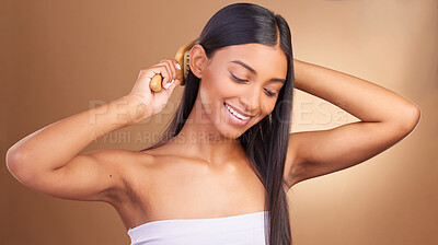 Buy stock photo Beauty, smile and Indian woman with hair brush in studio for shampoo, results or scalp wellness on brown background. Haircare, texture and lady model happy with growth, keratin or volume satisfaction