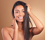 Hair, beauty and portrait of happy Indian woman in studio for cosmetic, wellness or texture and growth on brown background. Haircare, face and lady model smile for keratin, volume or shampoo results