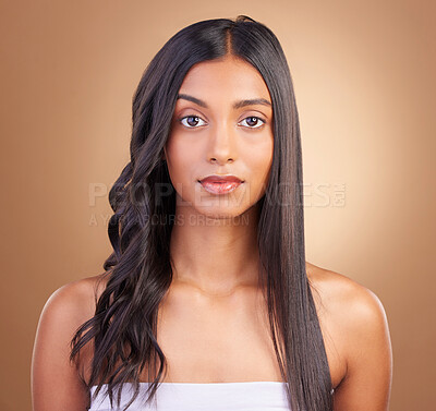 Buy stock photo Portrait, serious and a woman with hair care on a studio background for texture or growth from a salon. Hairstyle, wellness and a young Indian model or girl with beauty for styling or change