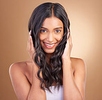 Portrait, hair care and woman with a smile, beauty and cosmetics on a brown studio background. Face, person and model with dermatology, aesthetic or glow with shine, texture and volume with wellness
