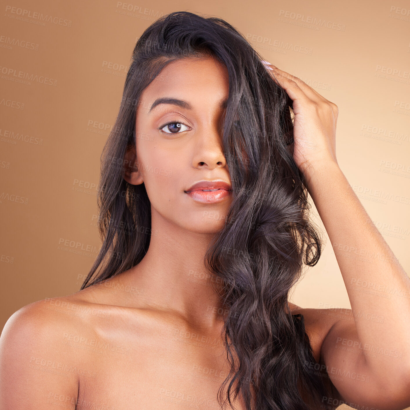 Buy stock photo Portrait, indian woman and beauty in studio of curly hair, aesthetic glow and skincare on brown background. Face of model, wavy hairstyle texture and shampoo for keratin, dermatology and cosmetics
