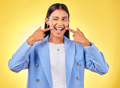 Buy stock photo Fingers on cheek, smile and a happy woman in studio for positive attitude, dimples and emoji. Indian model person or student with fashion, comic and funny face or silly mood on a yellow background