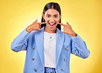 Fingers on cheek, portrait and a happy woman in studio for positive attitude, dimples and emoji. Indian model person or student with fashion, comic and excited face or silly mood on yellow background
