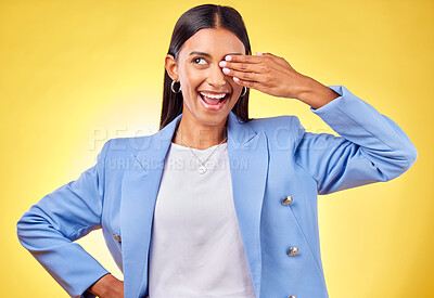 Buy stock photo Fashion, smile and vision with a business indian woman on a yellow background in studio for work style. Hand, eye and a happy young professional person thinking of an idea for her corporate future
