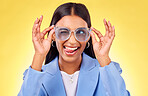 Funny, silly woman and sunglasses with tongue out, comedy and face in a studio. Yellow background, crazy and young female person with modern fashion, trendy cool style and creative work clothing