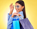Shopping, bag and portrait of woman as a happy customer for retail fashion isolated in a studio yellow background. Smile, Product, sale and young person with discount, deal or promo on clothes