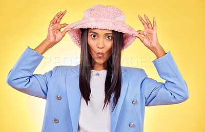 Buy stock photo Portrait, fashion and hat with a trendy indian woman on a yellow background in studio for style. Comic, clothes or accessories and a confident young model posing with a pout in pink headwear