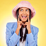 Fashion, thinking and face of woman on yellow background with funny, goofy and playful expression. Emoji, happiness and happy person in studio smile h in trendy clothes, style and outfit with hat