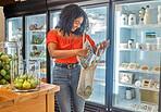 Black woman, shop and customer with grocery for bag, food and happy for shopping with zero waste in eco friendly supermarket. Sustainable, store and retail person with healthy fruits and vegetables