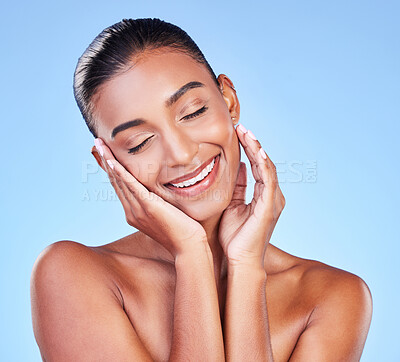 Buy stock photo Skincare, peace and hand on face with happy woman in studio with blue background and dermatology or cosmetics. Indian, model and happiness with natural skin and healthy facial glow or beauty care